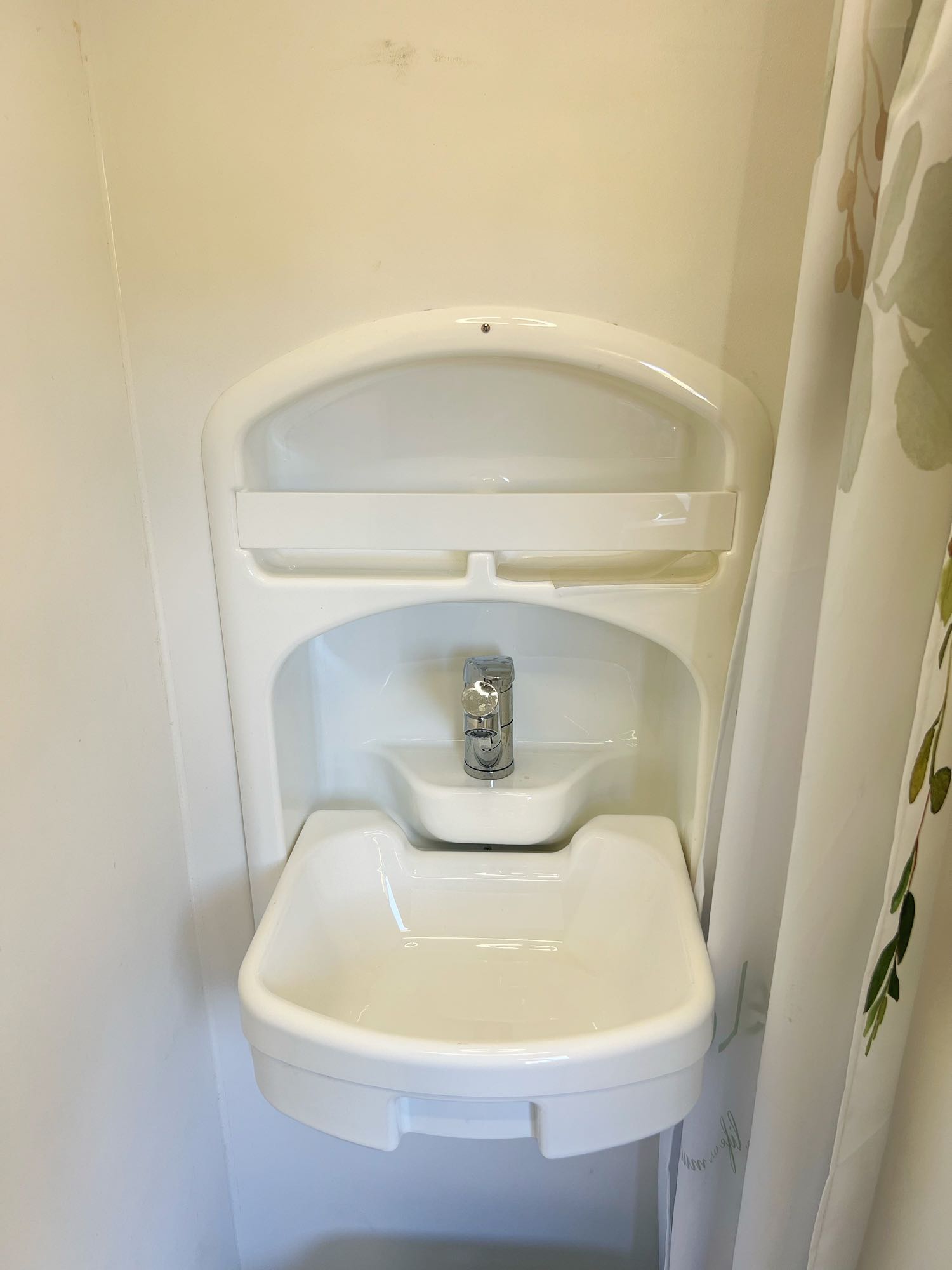 Compact bathroom sink and faucet, a key amenity in this RV rental.