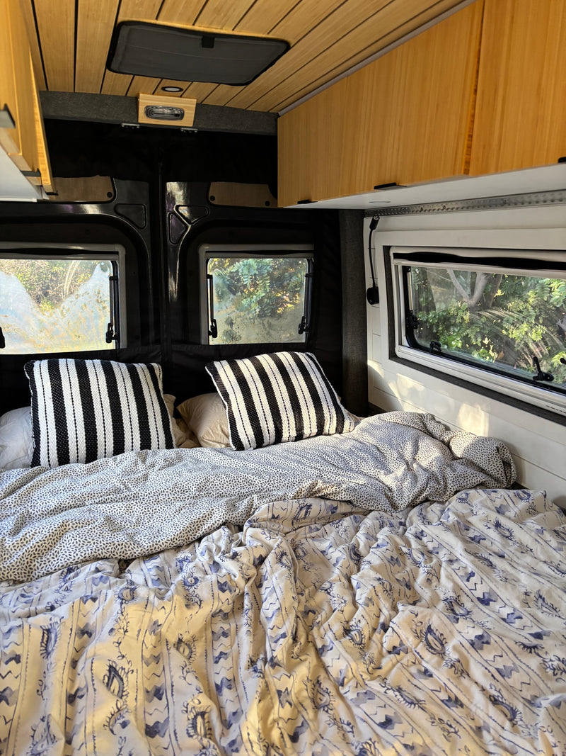  and versatile sink with wooden cover.|RV rental: Modern camper van interior with open back doors — photo 13