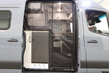 This RV rental shows its gray camper van interior through an open side door, covered by a transparent bug screen.