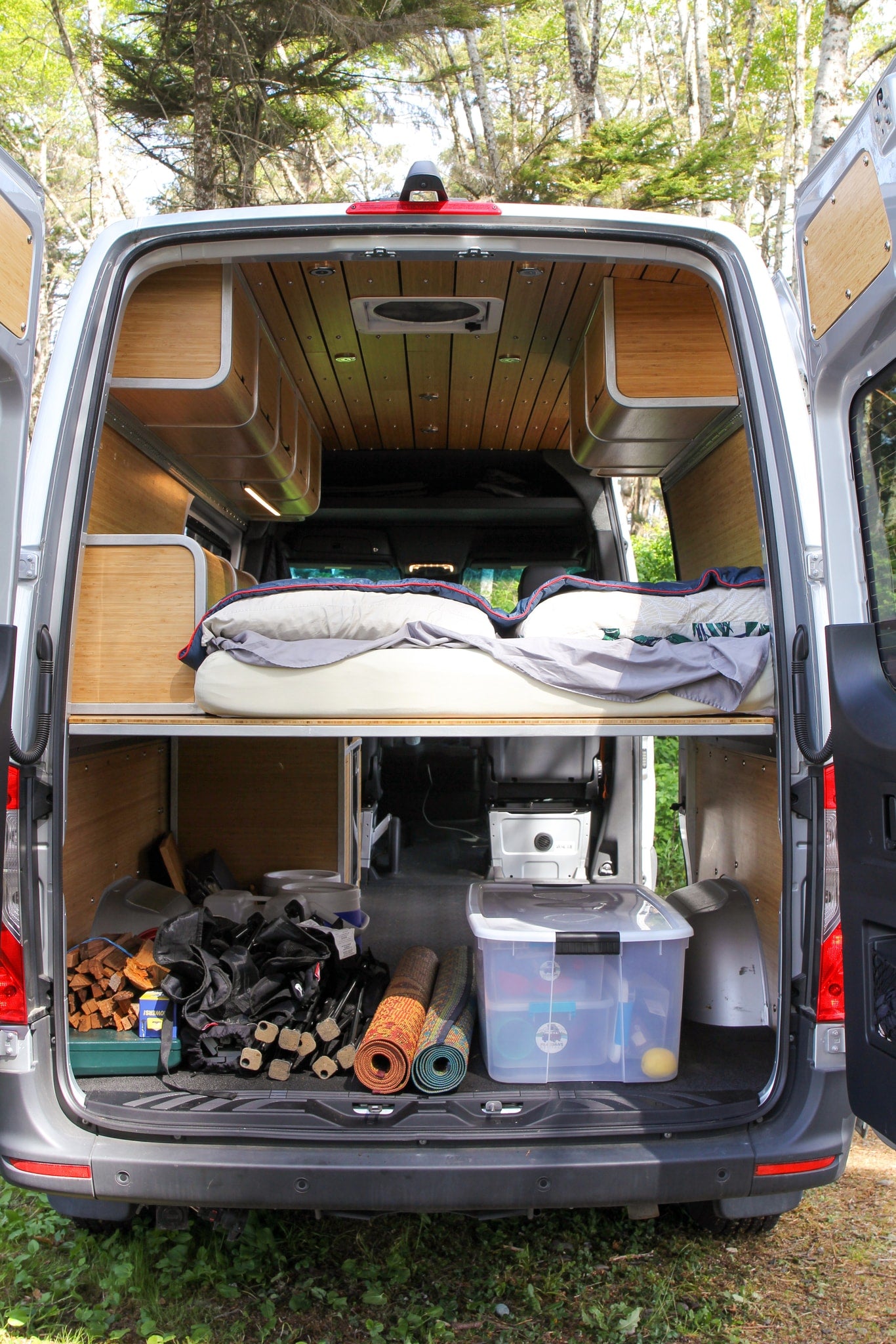 Explore this RV rental's clever interior: a comfortable raised bed, ample under-bed storage, and tasteful wood finishes. — photo 8