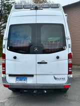 Rear view of a white Mercedes Sprinter RV rental van with roof lights, Connecticut plate, and a "VALKYRIE" sticker.