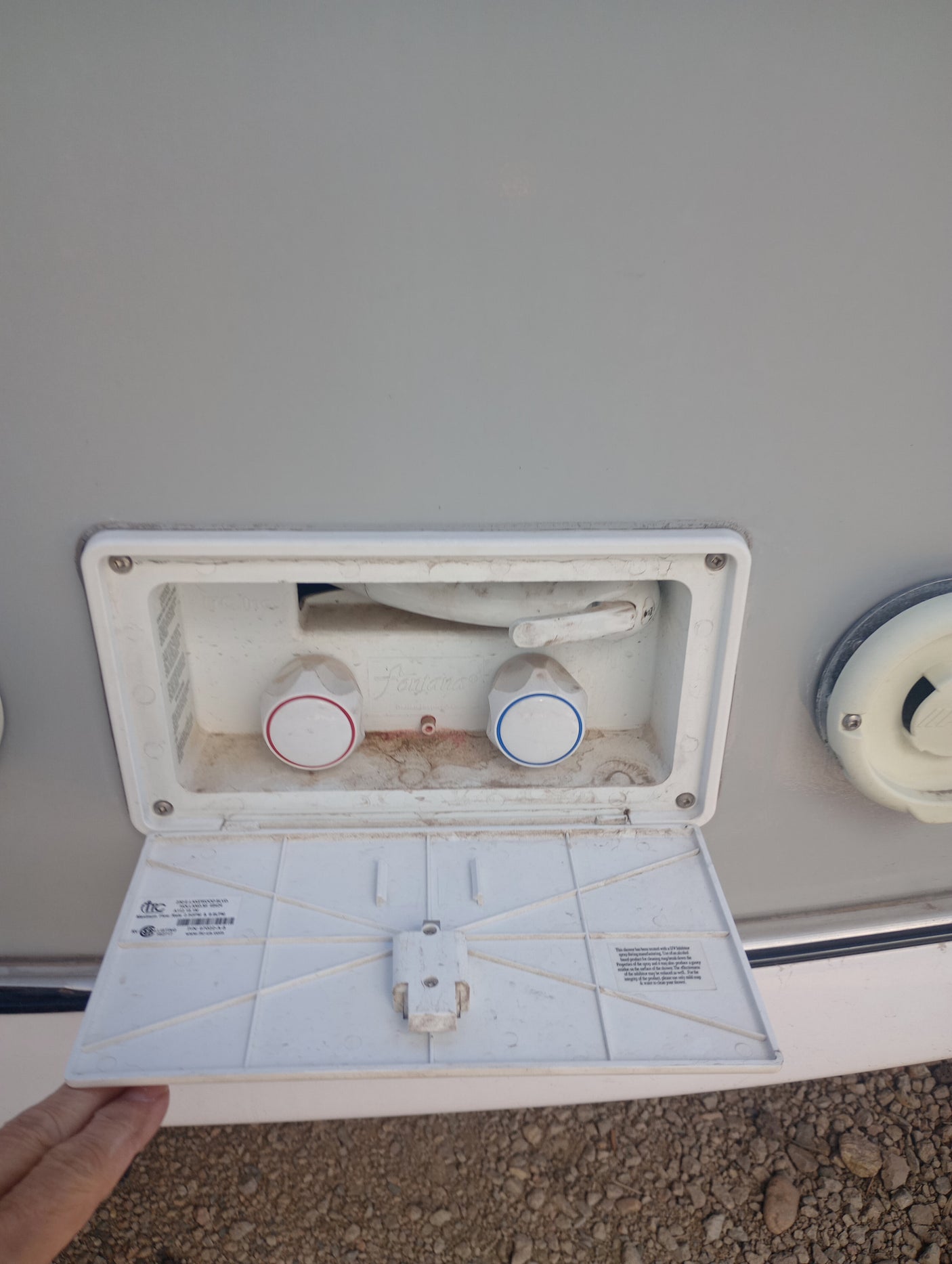 RV rental outdoor shower with hot (red) and cold (blue) water controls visible.