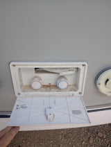 RV rental outdoor shower with hot (red) and cold (blue) water controls visible.