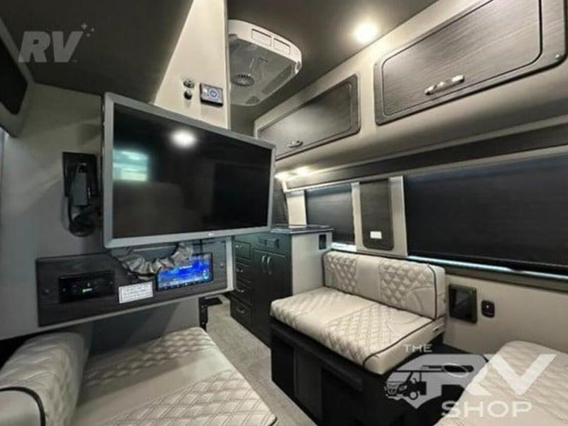  featuring quilted light-colored seats and a modern compact kitchen. Ready for your next adventure!|This luxury rv rental features a spacious — photo 10