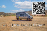 A gray RV rental camper van sits in a dirt lot with mountains. Scan the QR code for a 3D virtual tour of this adventure vehicle.