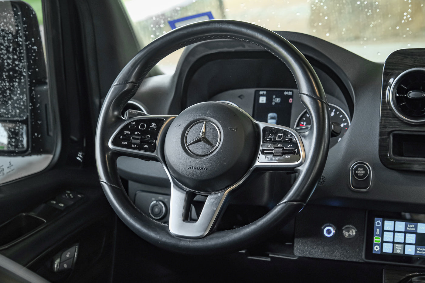 Inside a modern Mercedes-Benz RV rental: a detailed view of the steering wheel and dashboard controls, ready for adventure. — photo 19