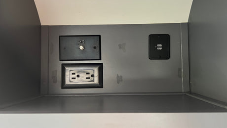 Inside an RV rental: a power panel with a coaxial hookup, standard AC outlet, and dual USB charging ports.