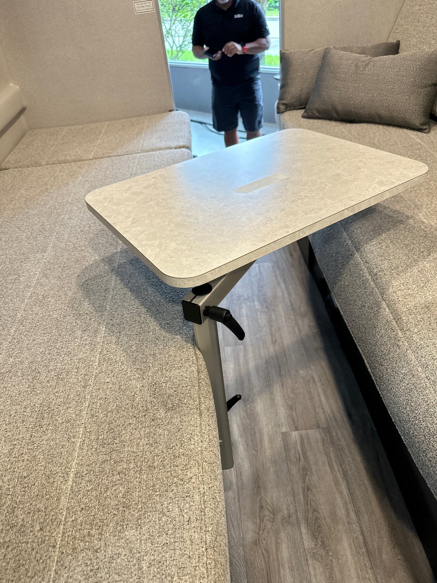 This rv rental interior showcases a versatile living area with modular sofa/beds and an adjustable table.