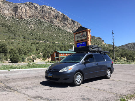 Ready for adventure! A minivan with a rooftop tent, like an RV rental, parked at Mount Charleston Resort, Nevada, with mountains.
