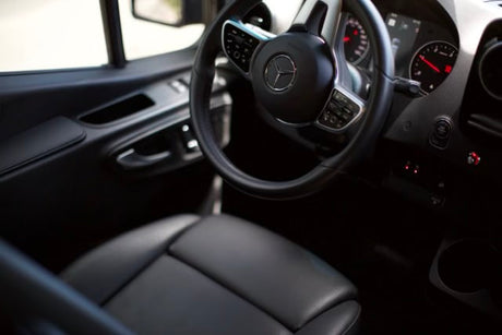 Interior of a premium **rv rental**, showing the Mercedes-Benz steering wheel, dashboard, and comfortable driver's seat.