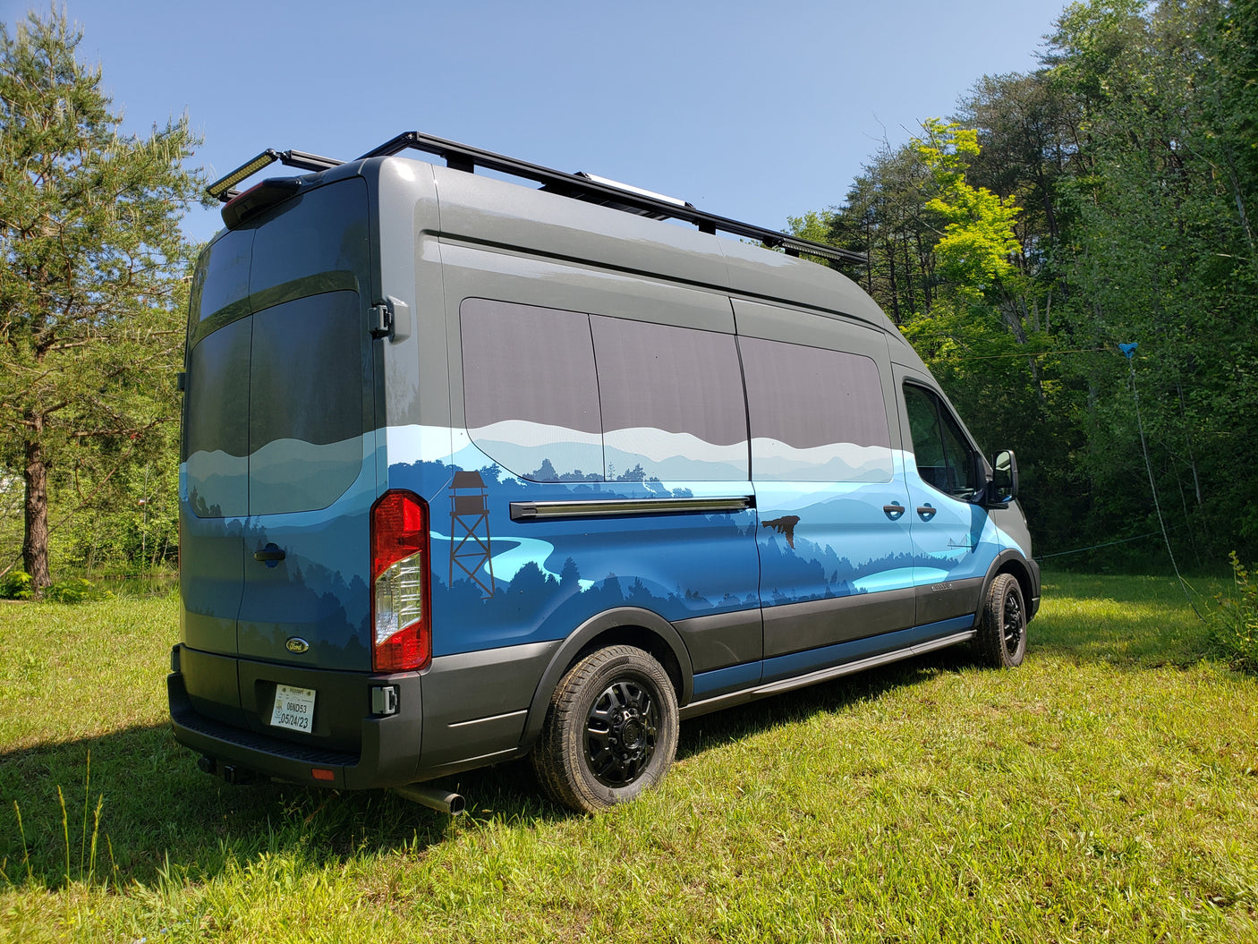 Experience the outdoors with this custom Ford Transit RV rental, featuring a unique mountain and forest mural.
