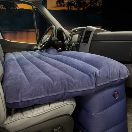 RV rental front seat air mattress for car camping: comfy sleeping setup in a van, with a twilight lake view outside.