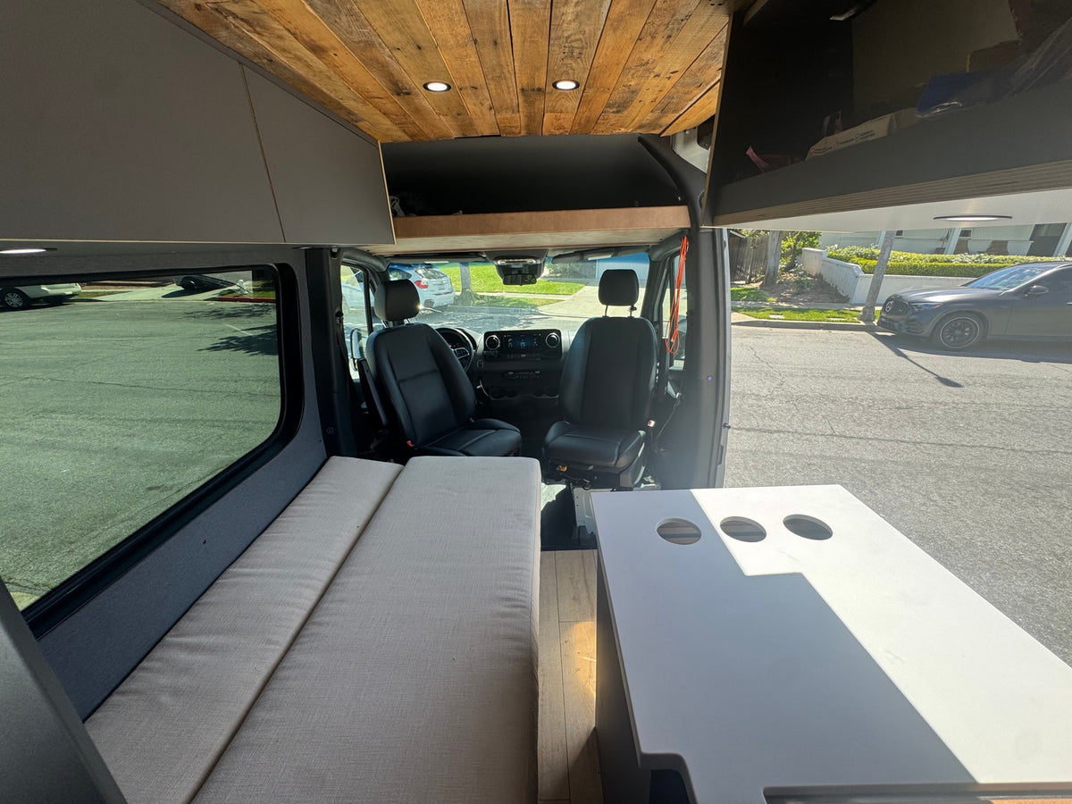 Camper van rv rental interior: wooden ceiling, bench bed, driver's area, and a table with cupholders. Ready for your trip! — photo 14