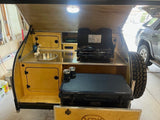 Explore this rv rental teardrop camper's rear galley: sink, stove, storage, & Yeti cooler. Ideal for outdoor adventures.