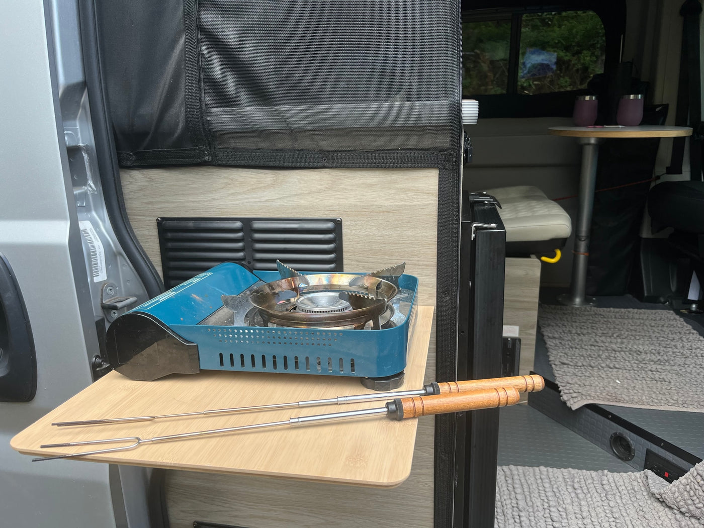 An RV rental's clever pull-out kitchen with a portable gas stove and roasting sticks, ready for camp meals. — photo 6