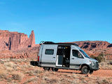 This Winnebago Sprinter van RV rental is parked among stunning red rock desert formations, ready for adventure.