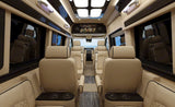 Spacious luxury RV rental interior with plush beige seating, an entertainment screen, and ambient lighting for ultimate comfort.
