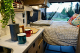 Cozy interior of an RV rental with kitchen area and comfortable bed, perfect for your next road trip adventure.