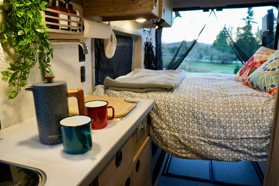 Cozy interior of an RV rental with kitchen area and comfortable bed, perfect for your next road trip adventure.