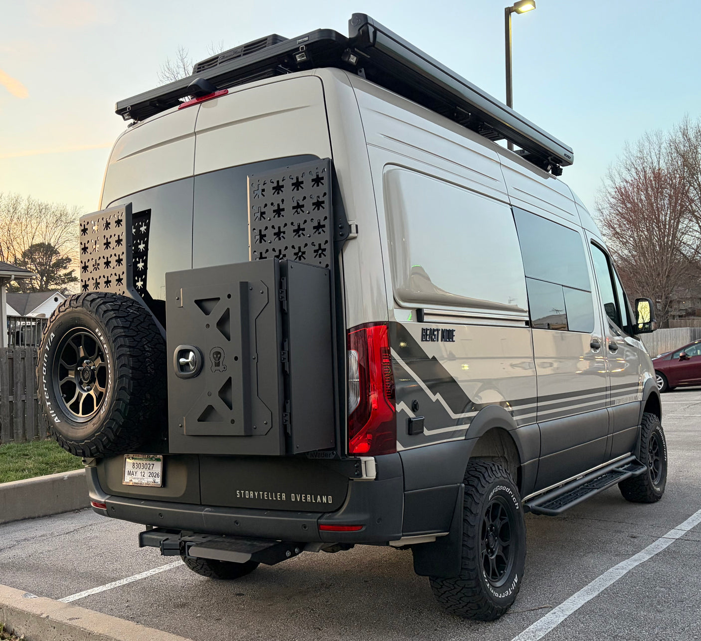A Storyteller Overland "Beast Mode" adventure van, perfect for an RV rental, with custom rear storage, spare tire, and roof rack.