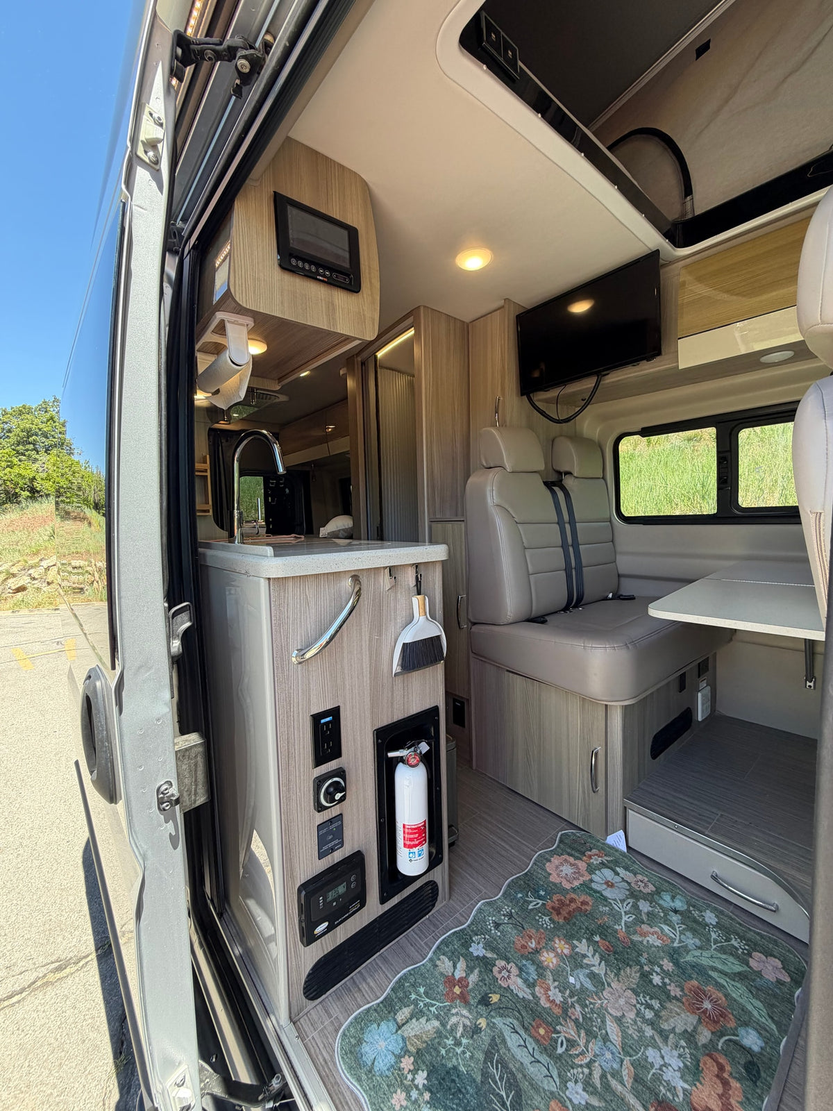 This rv rental features a bright camper van interior with a kitchen, dinette seating, and modern amenities for your road trip. — photo 5