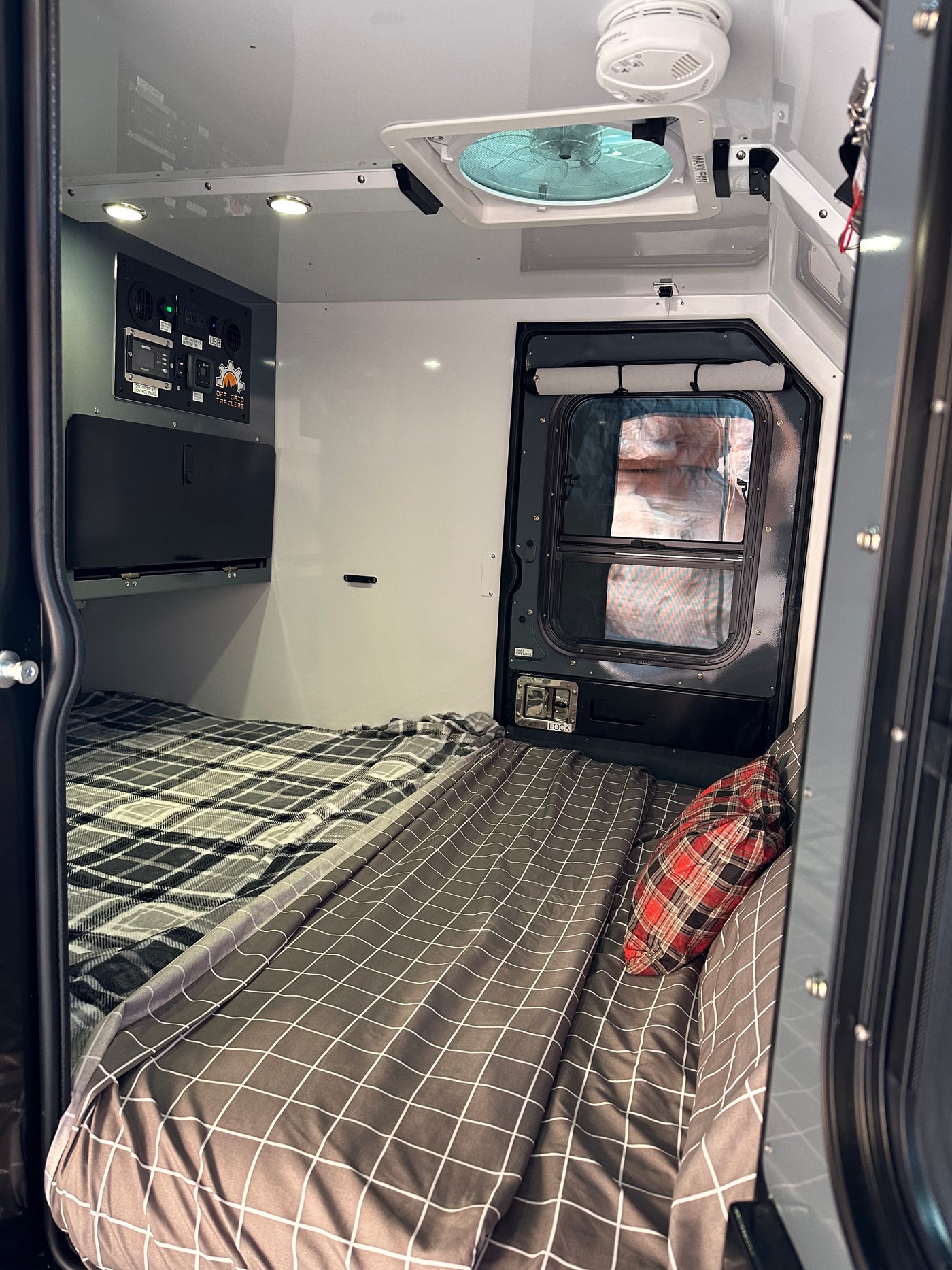 Cozy interior of an RV rental, featuring beds, control panel, and vent fan, ready for off-grid adventures. — photo 2