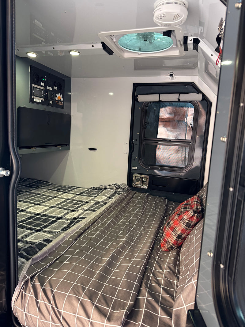 Cozy interior of an RV rental, featuring beds, control panel, and vent fan, ready for off-grid adventures. — photo 2