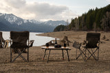 Enjoy the tranquility of nature with your RV rental. Cozy camping chairs, a table with wine, and a speaker by the lake.