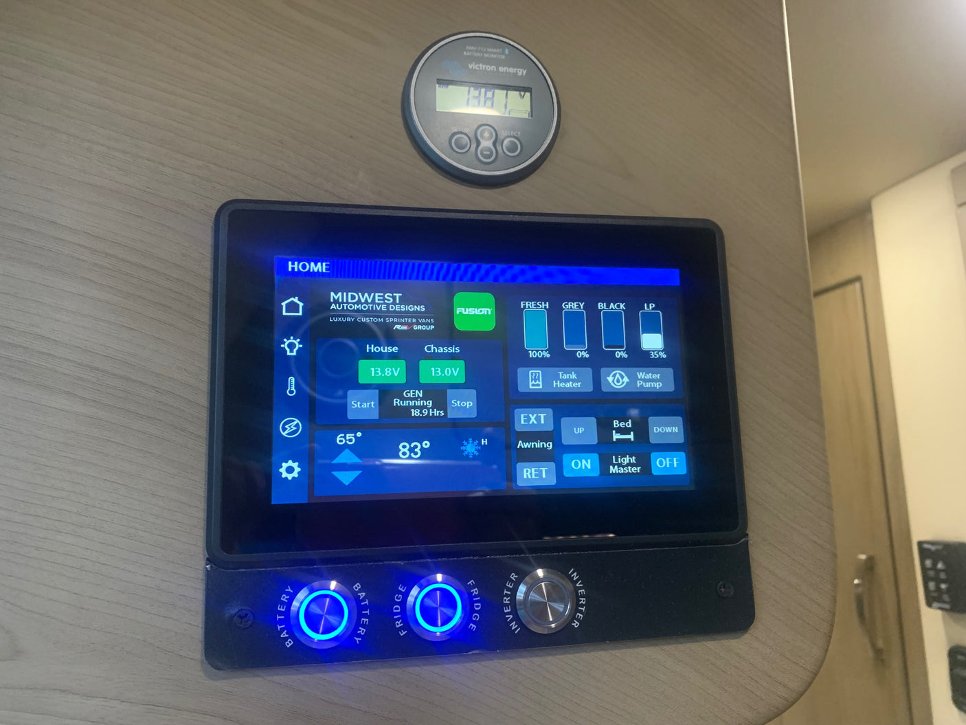 This RV rental's sophisticated control panel in a camper van displays battery, tank levels, generator status, and other system controls.
