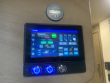 This RV rental's sophisticated control panel in a camper van displays battery, tank levels, generator status, and other system controls.