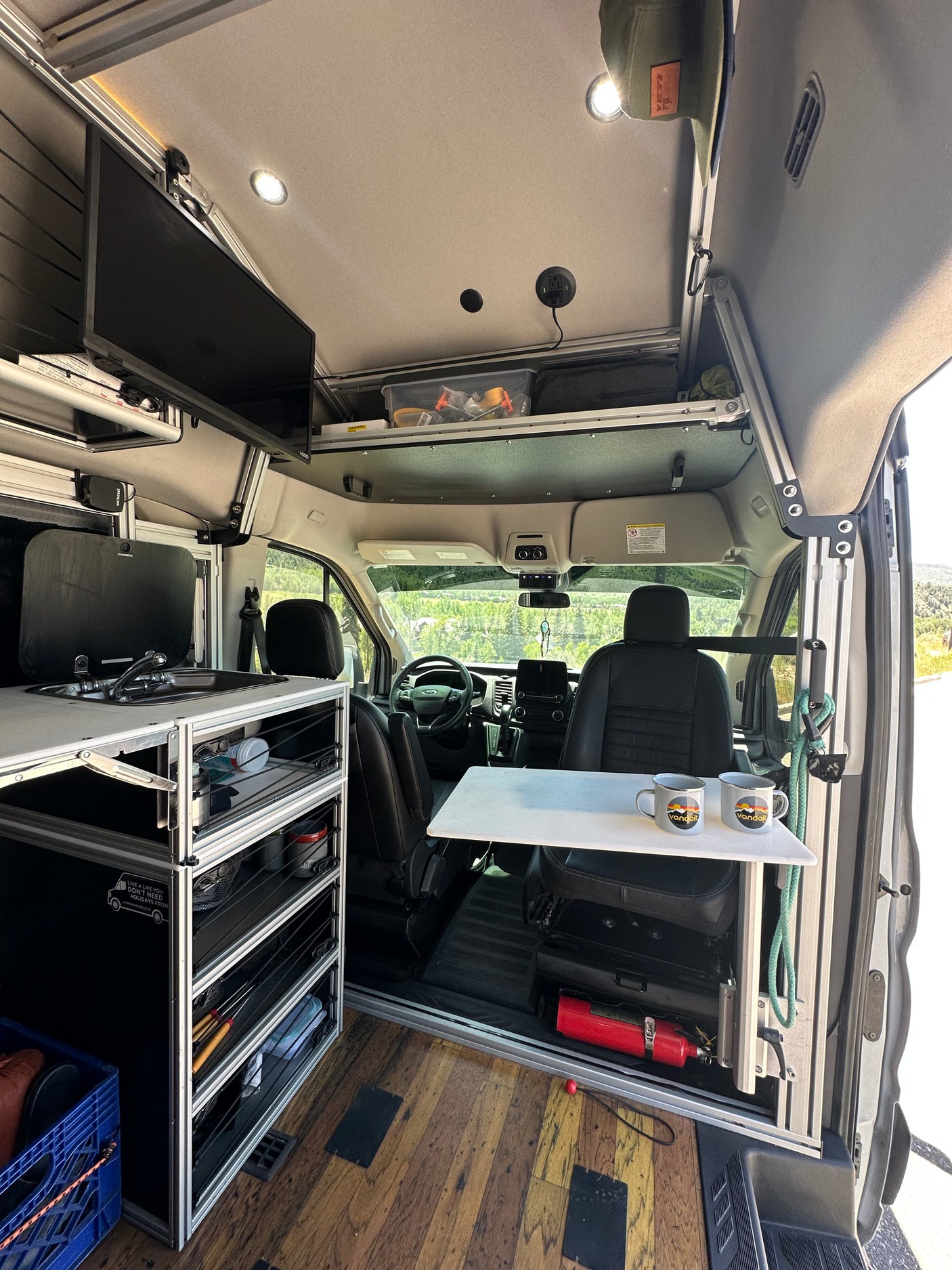 Modern rv rental interior featuring a practical kitchenette, smart storage solutions, and a versatile work/dining table.