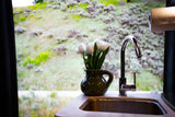 RV rental: Kitchen sink, modern faucet, white tulips, and scenic window view through the large window.