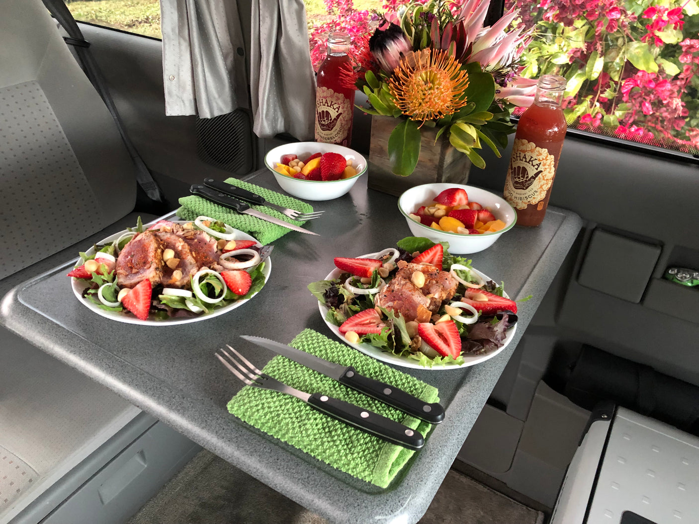 Fresh seared tuna salads, fruit bowls, and Hawaiian drinks in an RV rental. Enjoying a gourmet meal during a road trip.