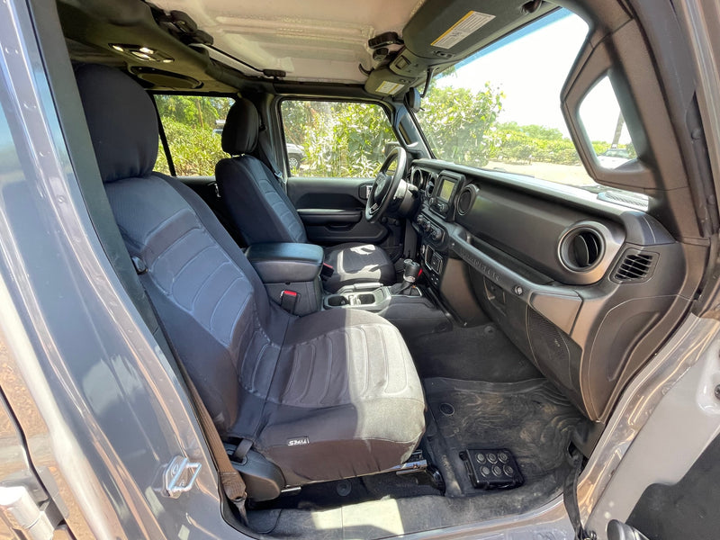 Experience a Jeep Wrangler's front cabin: dark seat covers, infotainment, and dash, perfect for your RV rental off-road adventure. — photo 6