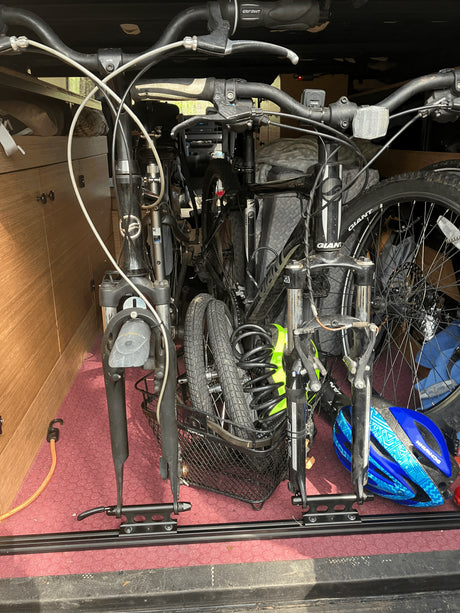 Bicycles stored securely inside an RV rental with a fork-mount system and helmet, ideal for adventure travel.