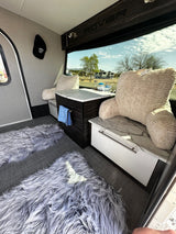 Cozy RV rental: interior features plush seating, modern cabinetry, and scenic outdoor views.