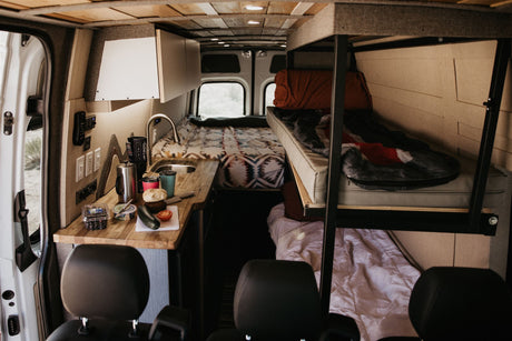Explore a spacious RV rental. This custom camper van features a kitchen, bunk beds, and comfy sleeping areas.