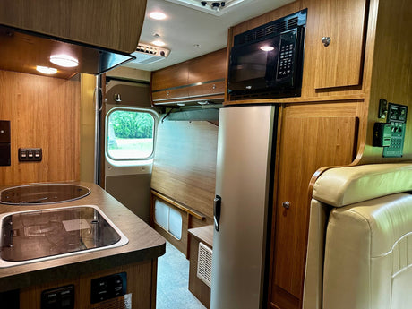  and flexible shower hose for space efficiency.|This rv rental interior highlights a compact kitchen