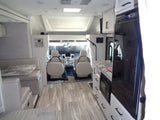 Bright, modern RV rental interior: kitchen with microwave/fridge, dining booth, and front cockpit. Comfortable travel.