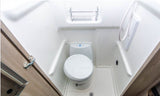 Compact RV rental bathroom features a toilet, shower, and storage rack. A practical wet bath design for travel.