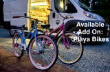RV rental offers an add-on: two colorful cruiser bikes parked near a white camper van with an open door.