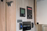 RV rental interior featuring control panels for Truma heater, Winnebago systems, and Xantrex solar charge controller.