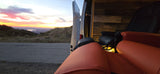 Golden hour relaxation: an rv rental with comfy seating, open to a stunning sunset, mountain, and lake view.