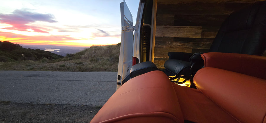 Golden hour relaxation: an rv rental with comfy seating, open to a stunning sunset, mountain, and lake view.