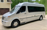 This silver Mercedes-Benz Sprinter Airstream RV rental is ready for adventure, parked on a sunny driveway.