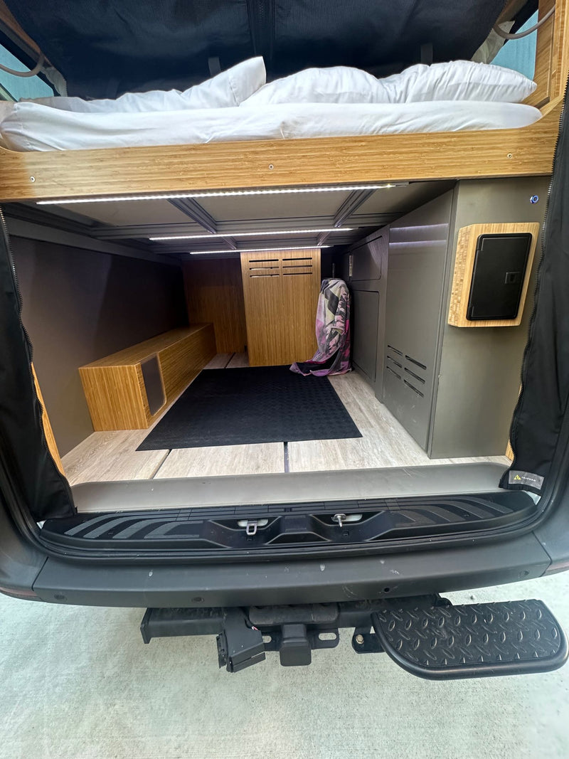  and large projection screen for entertainment.|Modern RV rental kitchen featuring wood cabinetry — photo 3