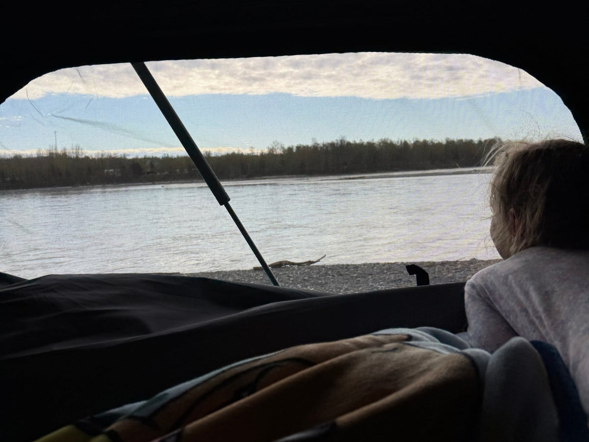  and a view of the street outside.|Interior of a rooftop tent featuring a large Teton sleeping bag — photo 8