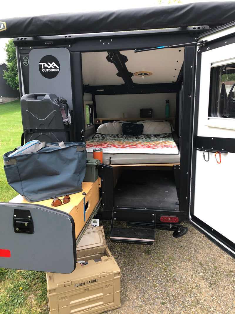 Inside this TAXA Outdoors rv rental: a cozy bed, ample storage, and organized outdoor gear for adventure. — photo 5