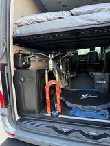 RV rental's clever design: a mountain bike secured under the elevated bed, with organized gear storage for adventures.