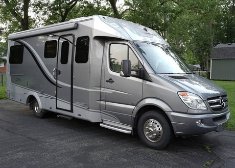 Grey Leisure Travel Unity RV rental on Mercedes-Benz Sprinter chassis, featuring a side awning & stylish decals.